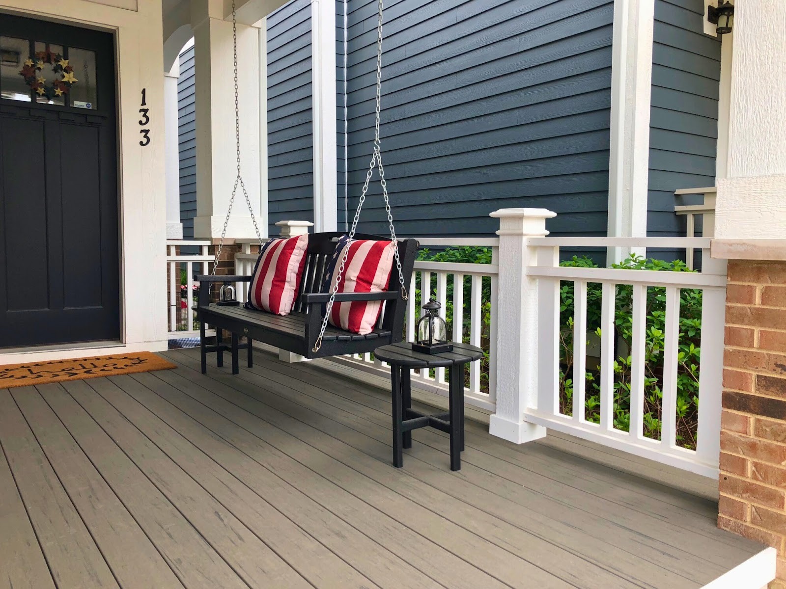 Front porch with composite decking, vinyl rails, and a porch swing in Libertyville, IL.